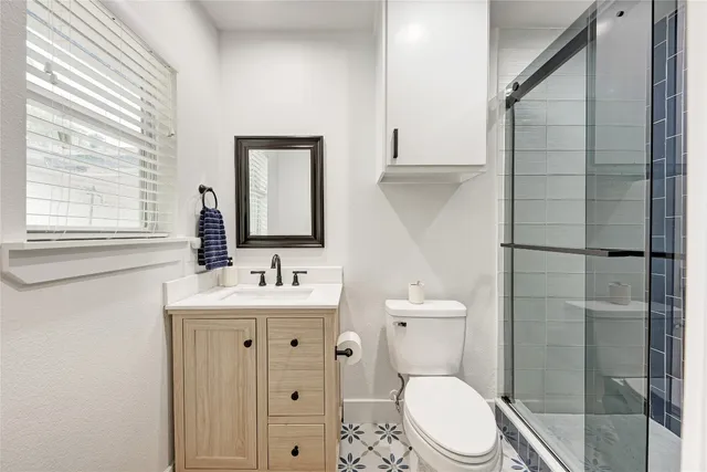 a bathroom with a toilet a sink a shower and mirror