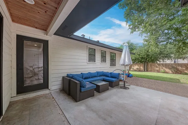 a view of backyard with outdoor seating and trees