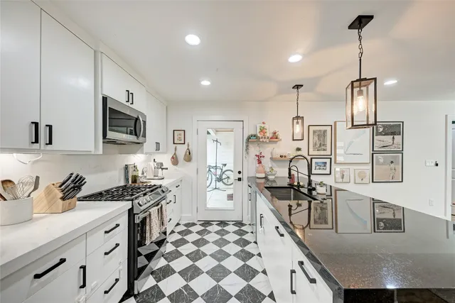 a kitchen with stainless steel appliances kitchen island granite countertop a sink and cabinets