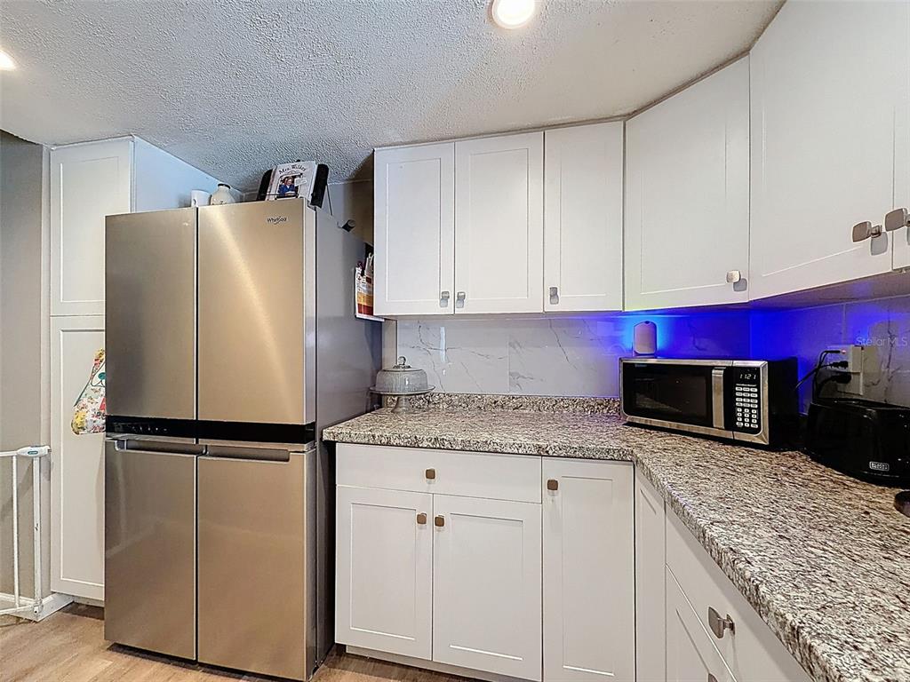 24350 Lanark Road Brooksville, FL 34601 - Photo 13 of 56 a kitchen with stainless steel appliances granite countertop a refrigerator sink and cabinets
