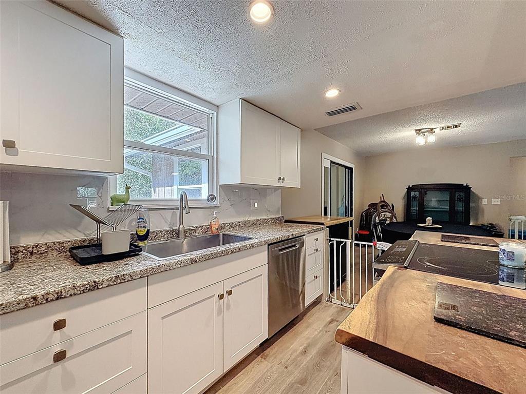 24350 Lanark Road Brooksville, FL 34601 - Photo 14 of 56 a kitchen with granite countertop stainless steel appliances a sink stove top oven and cabinets
