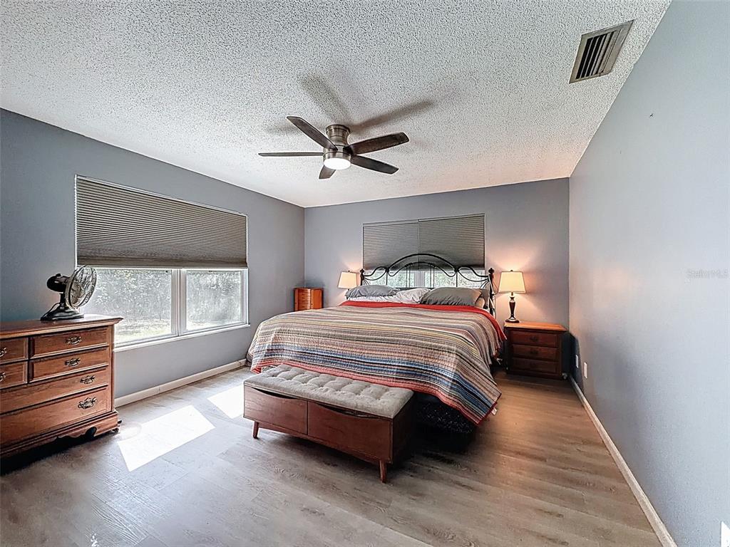24350 Lanark Road Brooksville, FL 34601 - Photo 15 of 56 a bedroom with a bed and a flat tv screen on dresser