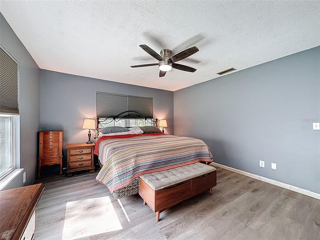24350 Lanark Road Brooksville, FL 34601 - Photo 16 of 56 a bedroom with a bed and a ceiling fan