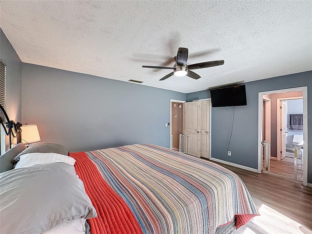 24350 Lanark Road Brooksville, FL 34601 - Photo 17 of 56 a bedroom with a large bed and a ceiling fan