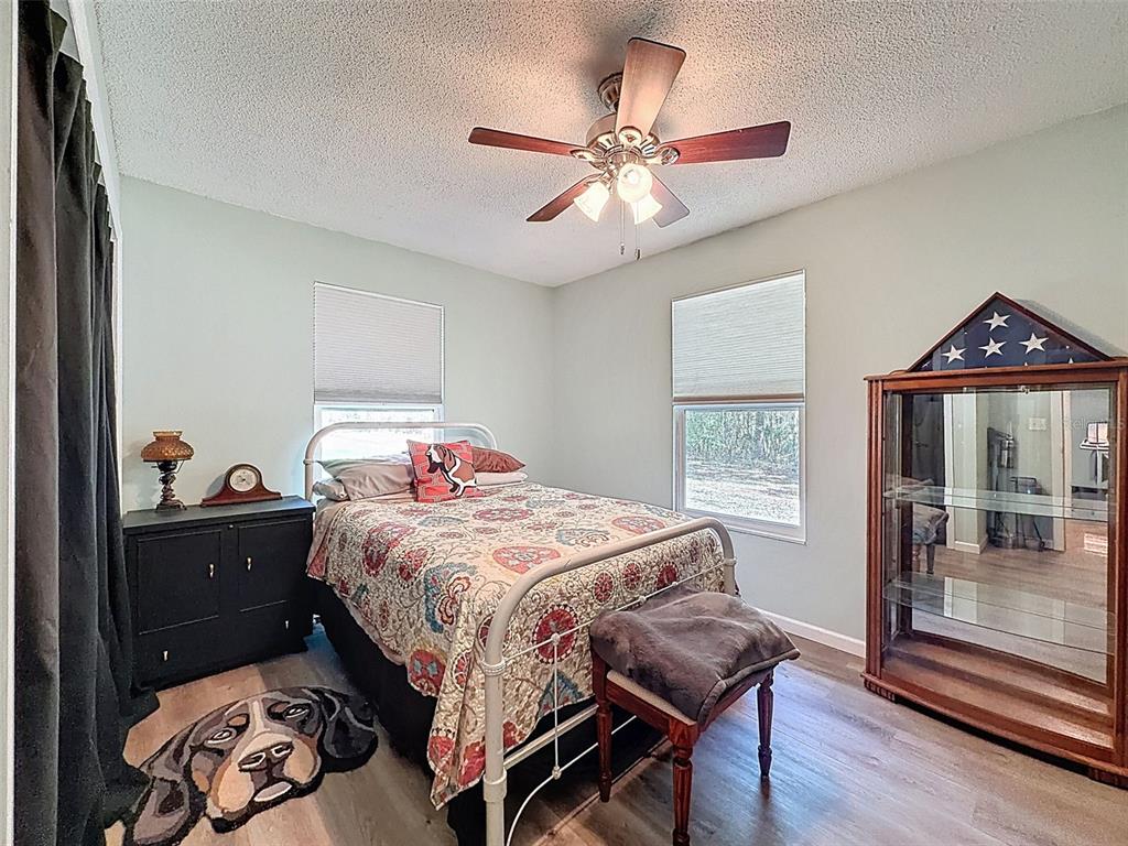 24350 Lanark Road Brooksville, FL 34601 - Photo 21 of 56 a bedroom with a bed and wooden floor