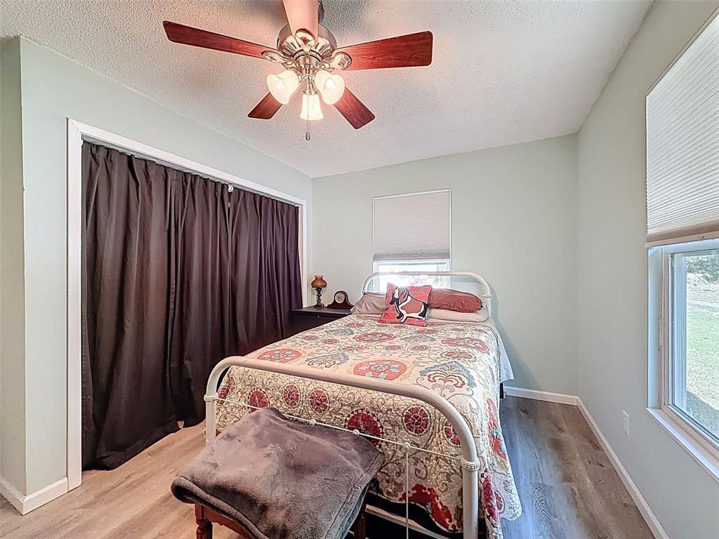 24350 Lanark Road Brooksville, FL 34601 - Photo 22 of 56 a bedroom with a bed and a chandelier