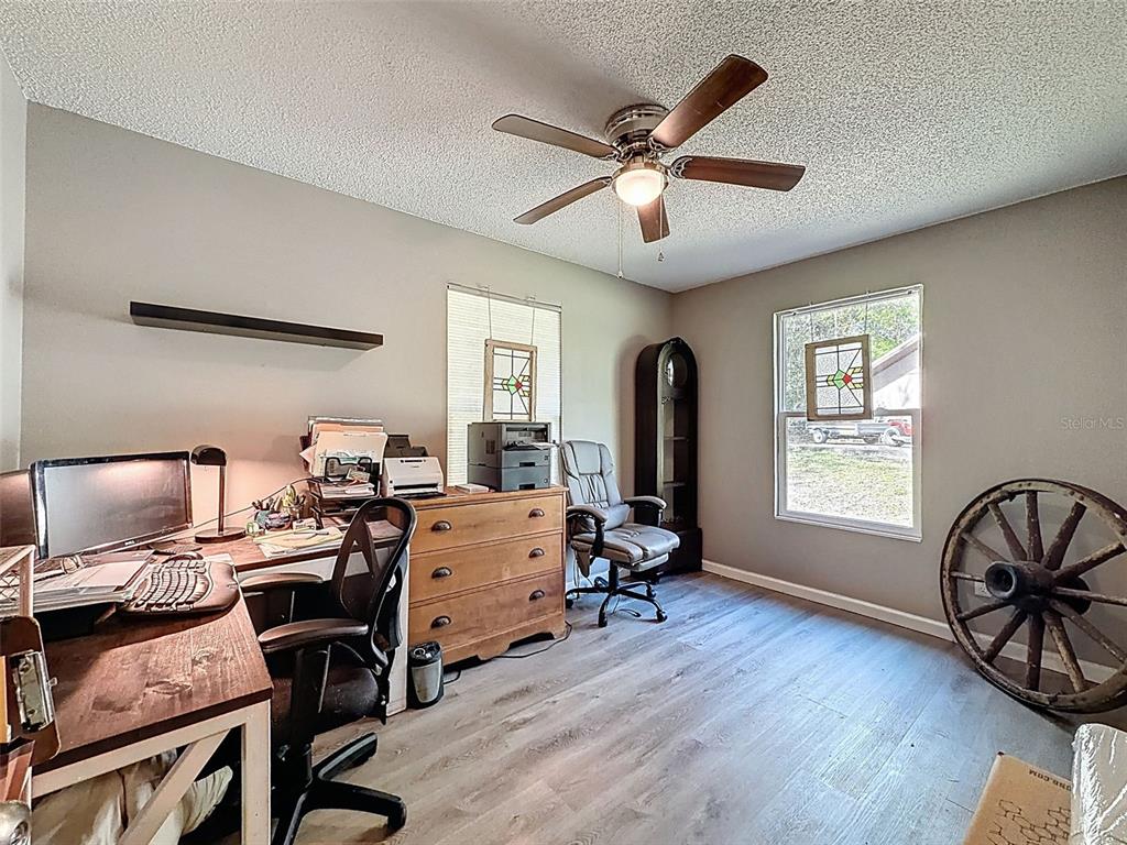 24350 Lanark Road Brooksville, FL 34601 - Photo 24 of 56 a workspace with furniture window and wooden floor