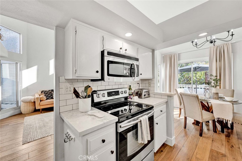 789 Grayling Bay Costa Mesa, CA 92626 - Photo 11 of 42 a kitchen with stainless steel appliances a stove a sink cabinets and a dining table