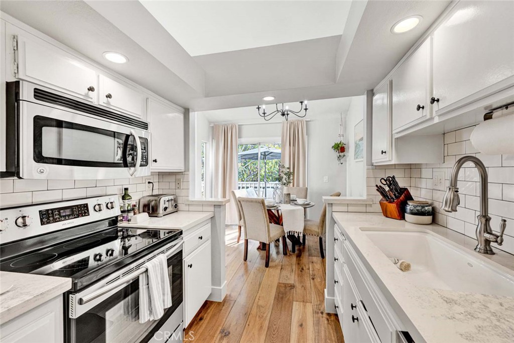 789 Grayling Bay Costa Mesa, CA 92626 - Photo 12 of 42 a kitchen with stainless steel appliances a stove sink microwave and cabinets