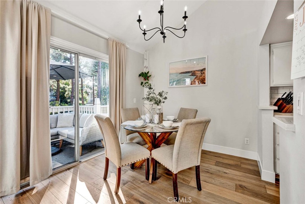 789 Grayling Bay Costa Mesa, CA 92626 - Photo 7 of 42 a view of a dining room with furniture wooden floor and a chandelier