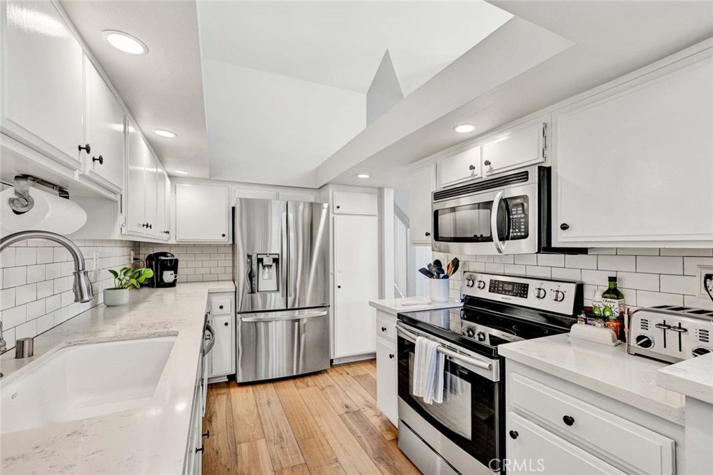 789 Grayling Bay Costa Mesa, CA 92626 - Photo 9 of 42 a kitchen with granite countertop a refrigerator stove and sink