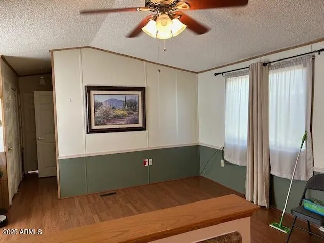 a view of a room with window ceiling fan and hardwood floor