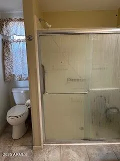 a bathroom with a toilet and a shower