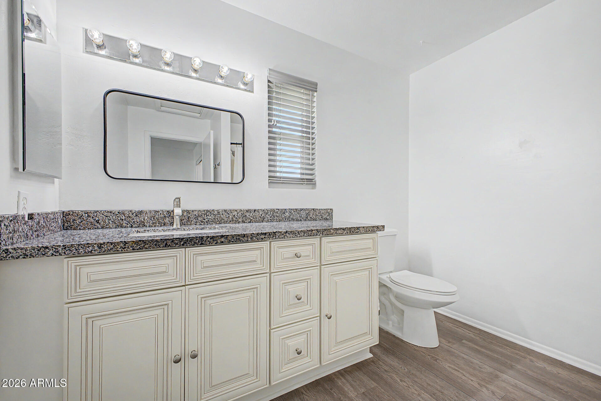 2455 East Broadway Road, Unit 103 Mesa, AZ 85204 - Photo 12 of 22 a bathroom with a toilet sink and mirror
