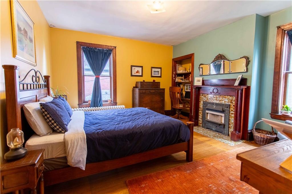 5901 Hampton Street Pittsburgh, PA 15206 - Photo 20 of 42 a bedroom with a bed and wooden floor