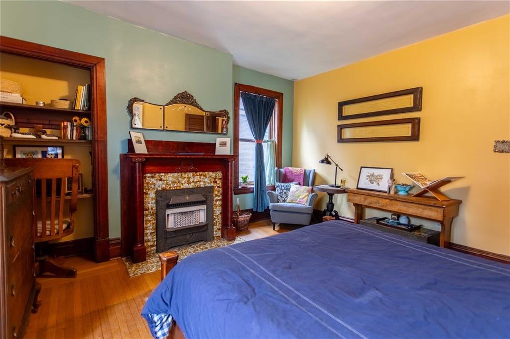 5901 Hampton Street Pittsburgh, PA 15206 - Photo 21 of 42 a bedroom with a bed and a fireplace