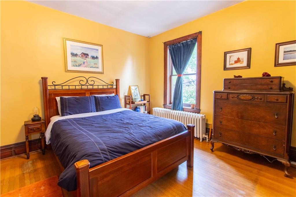 5901 Hampton Street Pittsburgh, PA 15206 - Photo 22 of 42 a bed sitting in a bedroom next to a window