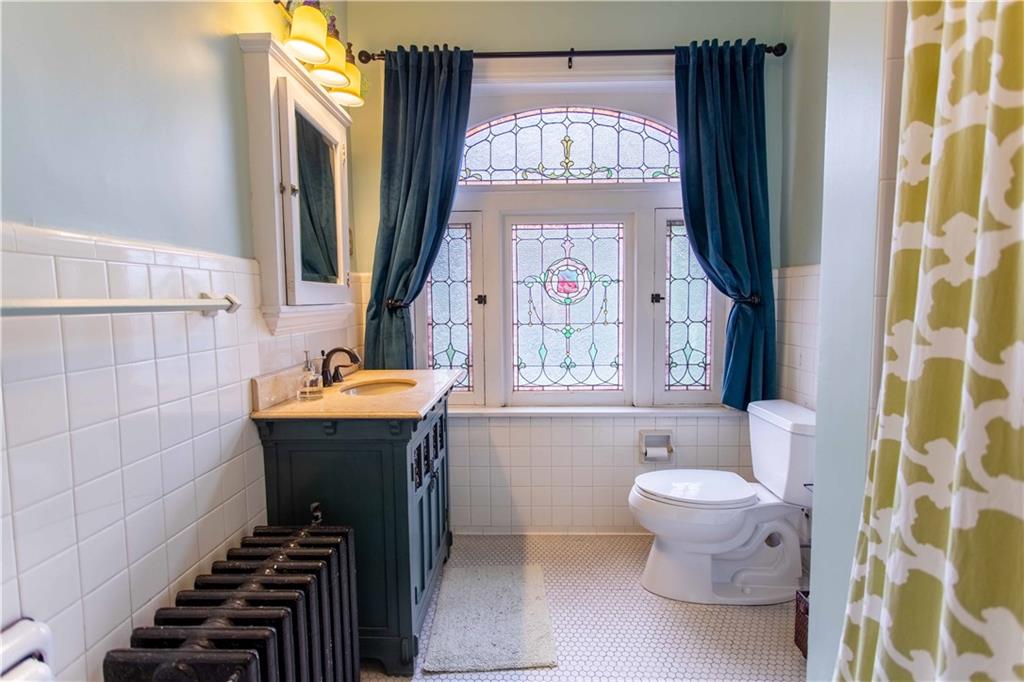 5901 Hampton Street Pittsburgh, PA 15206 - Photo 23 of 42 a bathroom with a toilet sink and mirror