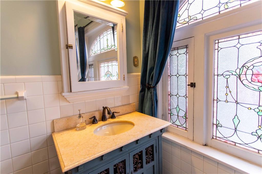 5901 Hampton Street Pittsburgh, PA 15206 - Photo 25 of 42 a bathroom with a granite countertop sink and a window