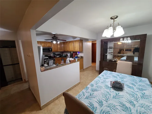 a kitchen with stainless steel appliances kitchen island granite countertop a refrigerator a stove top oven a sink and dishwasher