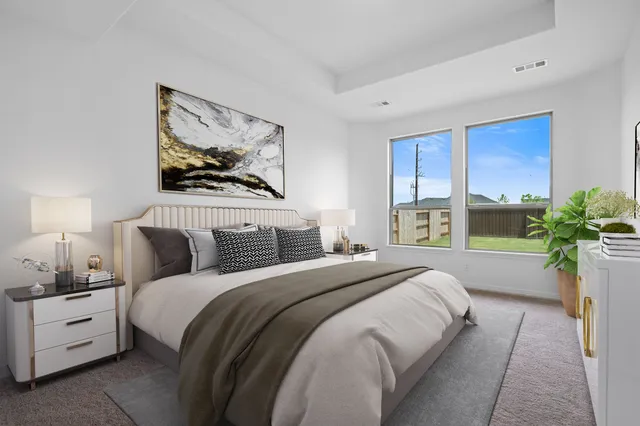 a spacious bedroom with a bed and a painting on the wall