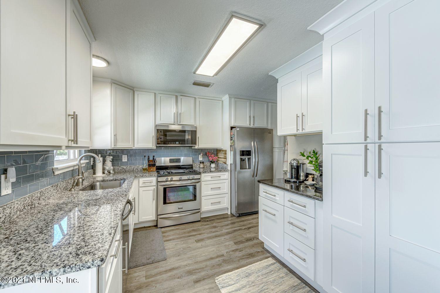 14443 Stacey Road Jacksonville, FL 32250 - Photo 7 of 16 a kitchen with white cabinets and stainless steel appliances
