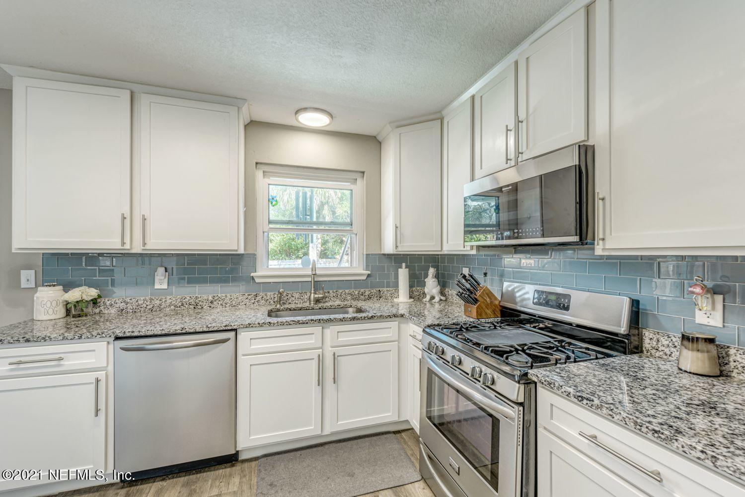 14443 Stacey Road Jacksonville, FL 32250 - Photo 8 of 16 a kitchen with granite countertop white cabinets and white appliances