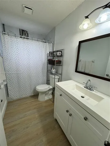 a bathroom with a sink toilet a mirror and shower