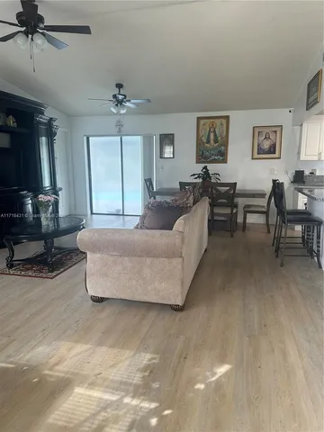 a living room with furniture a ceiling fan and a rug