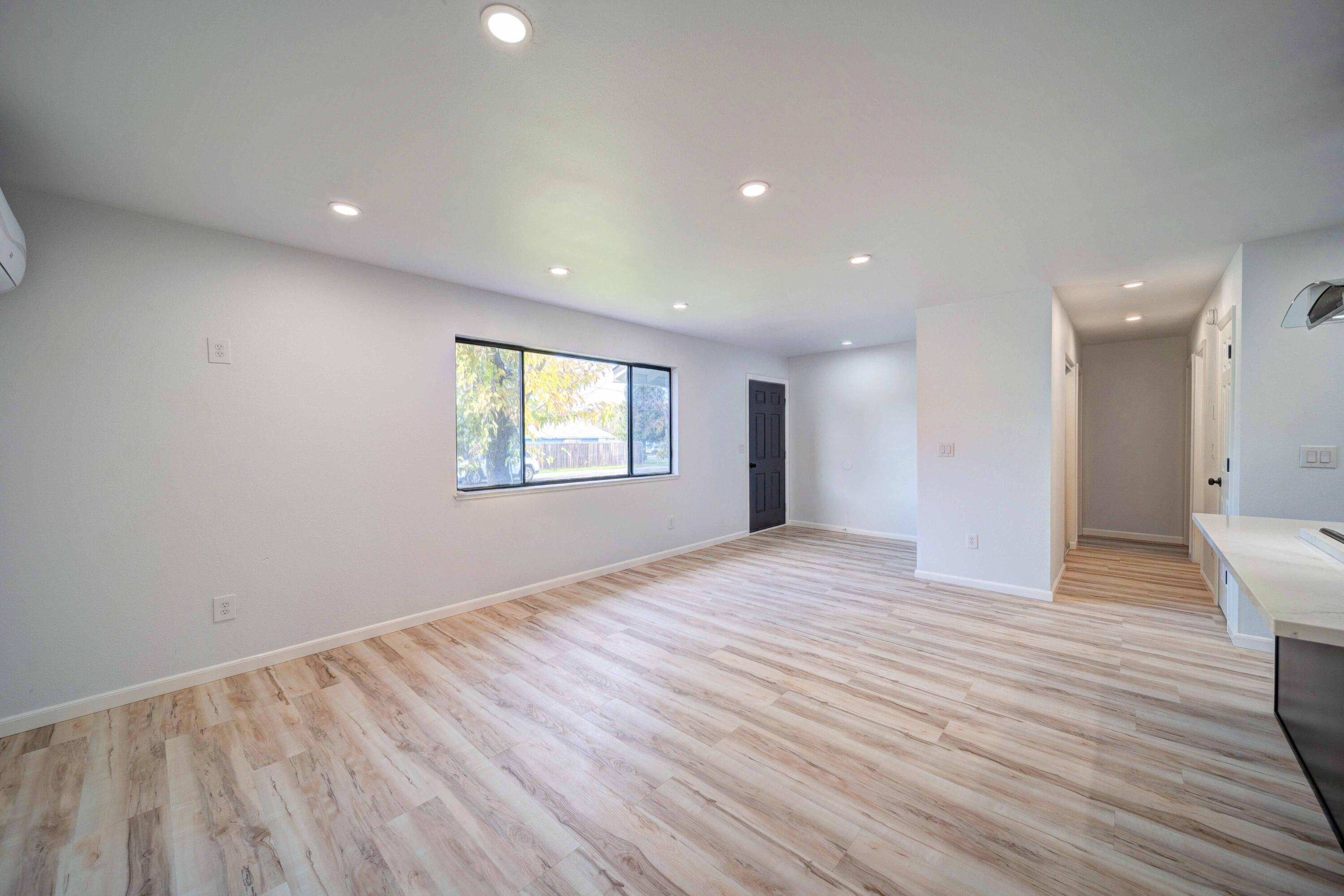 1611 2nd Street Anderson, CA 96007 - Photo 12 of 20 a view of an empty room with wooden floor and a window