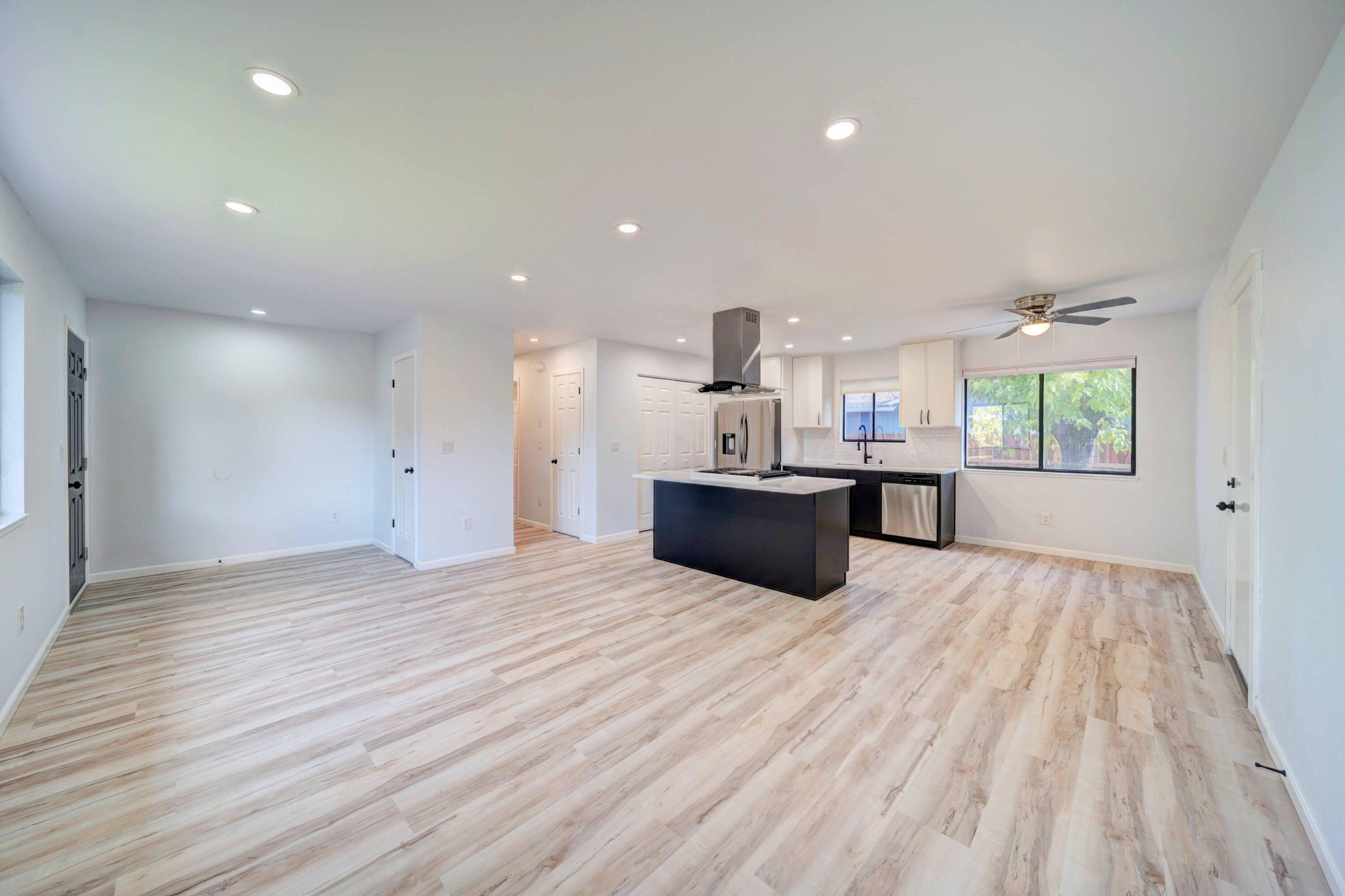 1611 2nd Street Anderson, CA 96007 - Photo 5 of 20 a view of kitchen and empty room with wooden floor and windows