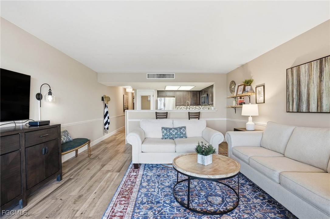 400 Lenell Road, Unit 706 Fort Myers Beach, FL 33931 - Photo 12 of 33 a living room with furniture a rug and a flat screen tv