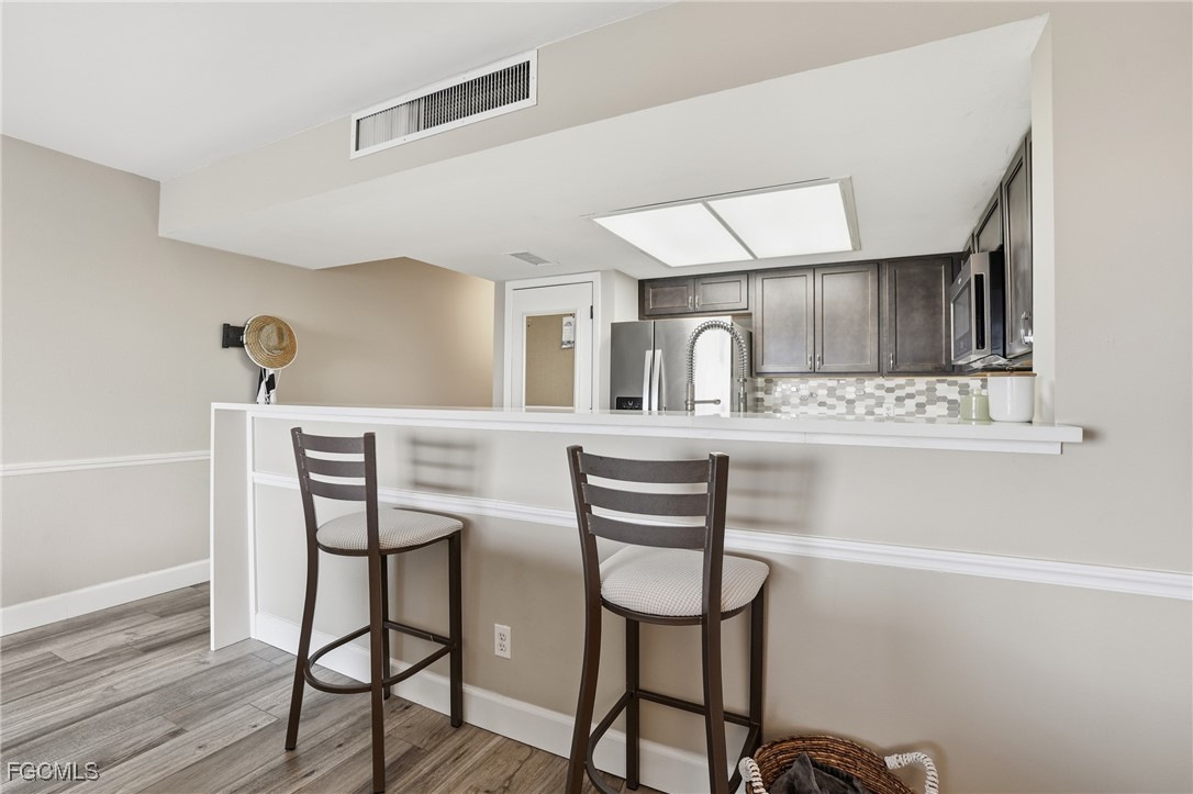 400 Lenell Road, Unit 706 Fort Myers Beach, FL 33931 - Photo 16 of 33 a kitchen with a table chairs refrigerator and sink