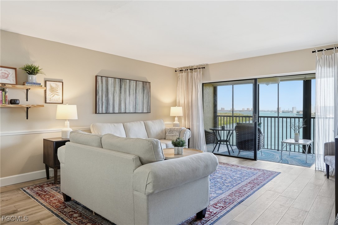 400 Lenell Road, Unit 706 Fort Myers Beach, FL 33931 - Photo 9 of 33 a living room with furniture and a floor to ceiling window