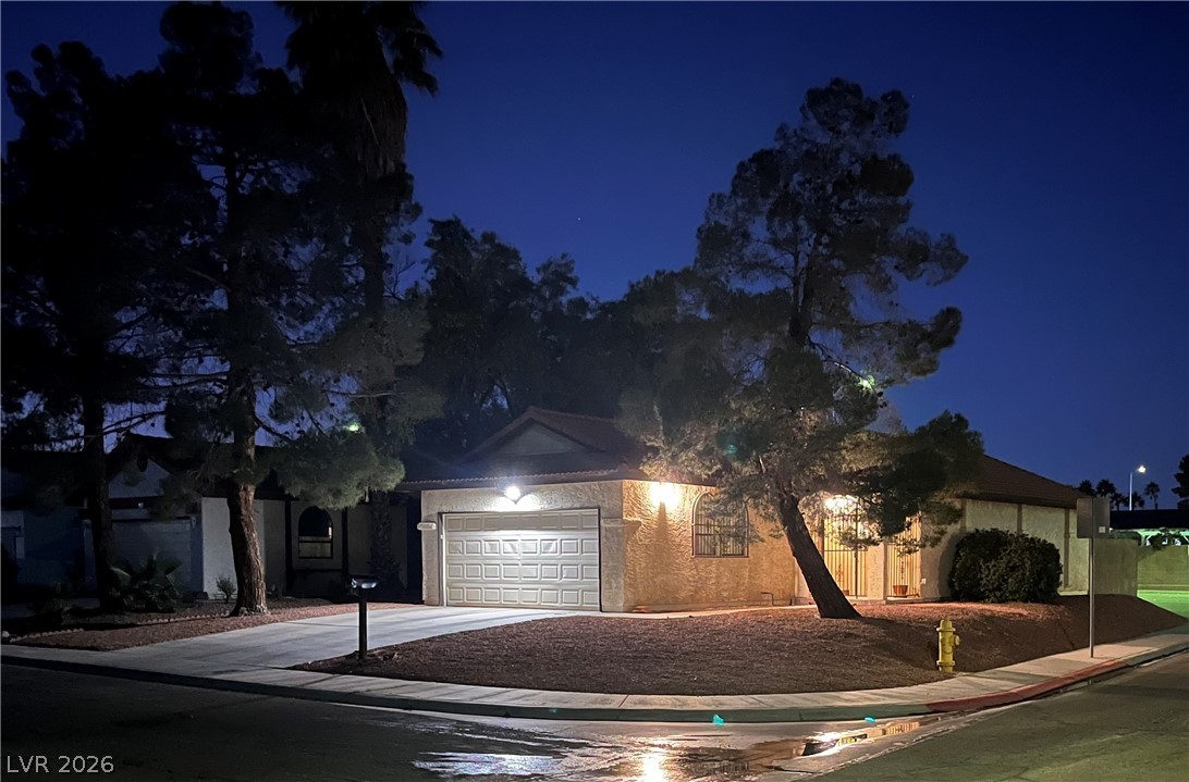 6412 West Pearcrest Road Las Vegas, NV 89108 - Photo 2 of 17 Illuminated at dusk, this inviting residence features mature trees and a neatly maintained front yard.