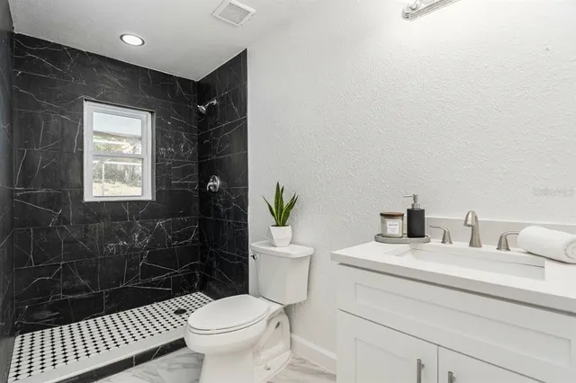 a bathroom with a sink toilet and shower