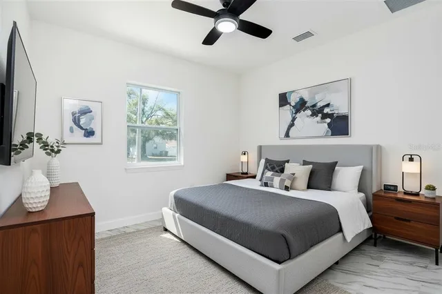 a bedroom with a large bed and a chandelier