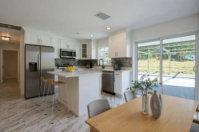 a kitchen with sink a refrigerator and wooden floor