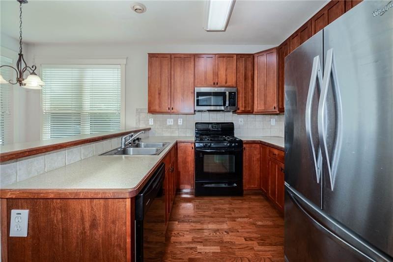 65 Orchard Drive Covington, GA 30014 - Photo 12 of 50 a kitchen with stainless steel appliances granite countertop a refrigerator a stove top oven a sink and dishwasher