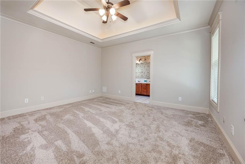 65 Orchard Drive Covington, GA 30014 - Photo 17 of 50 an empty room with a chandelier fan and windows