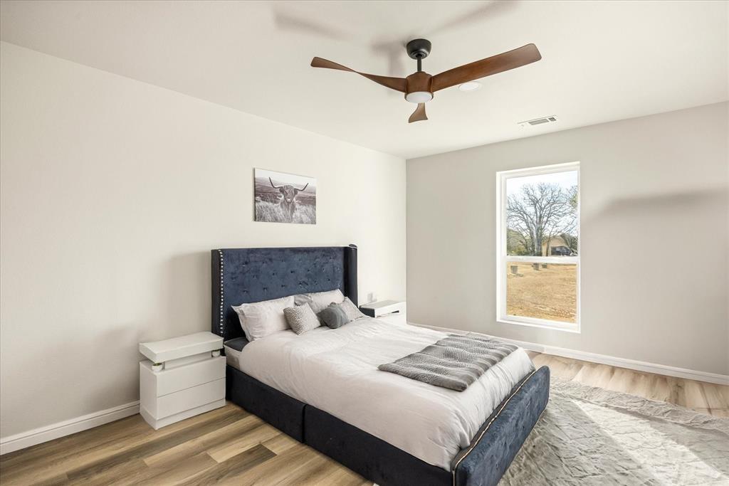 4801 West Wedgefield Road Granbury, TX 76049 - Photo 22 of 40 a bedroom with a large bed and a window