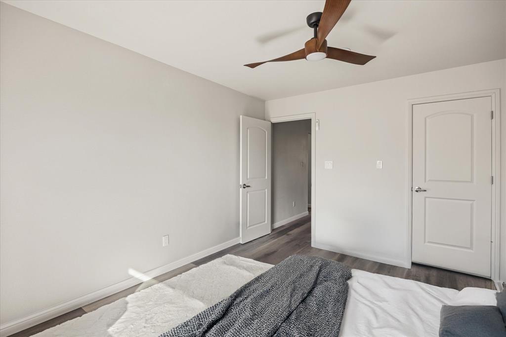 4801 West Wedgefield Road Granbury, TX 76049 - Photo 23 of 40 a bedroom with a bed and a chandelier fan