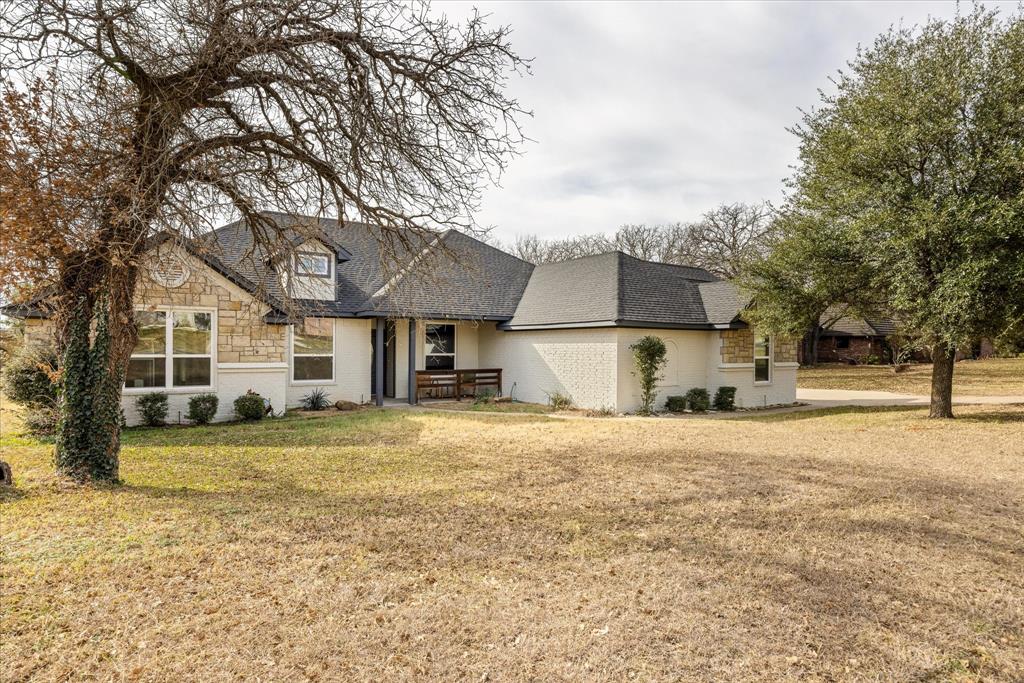 4801 West Wedgefield Road Granbury, TX 76049 - Photo 32 of 40 a front view of a house with a yard and garage