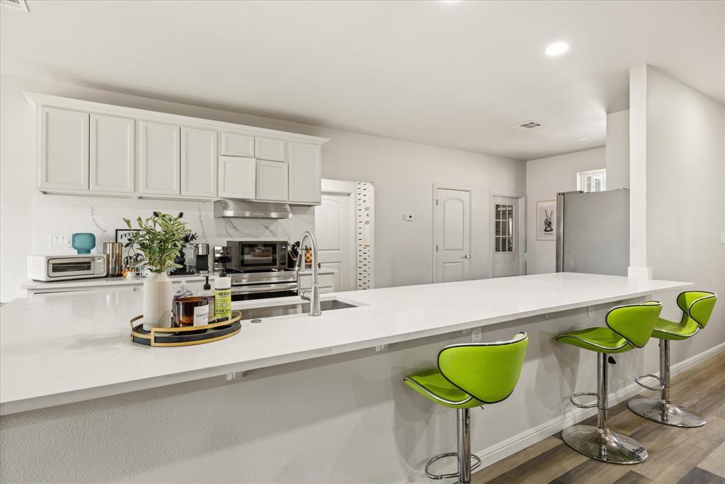 4801 West Wedgefield Road Granbury, TX 76049 - Photo 5 of 40 a kitchen with a refrigerator a stove and a counter top space