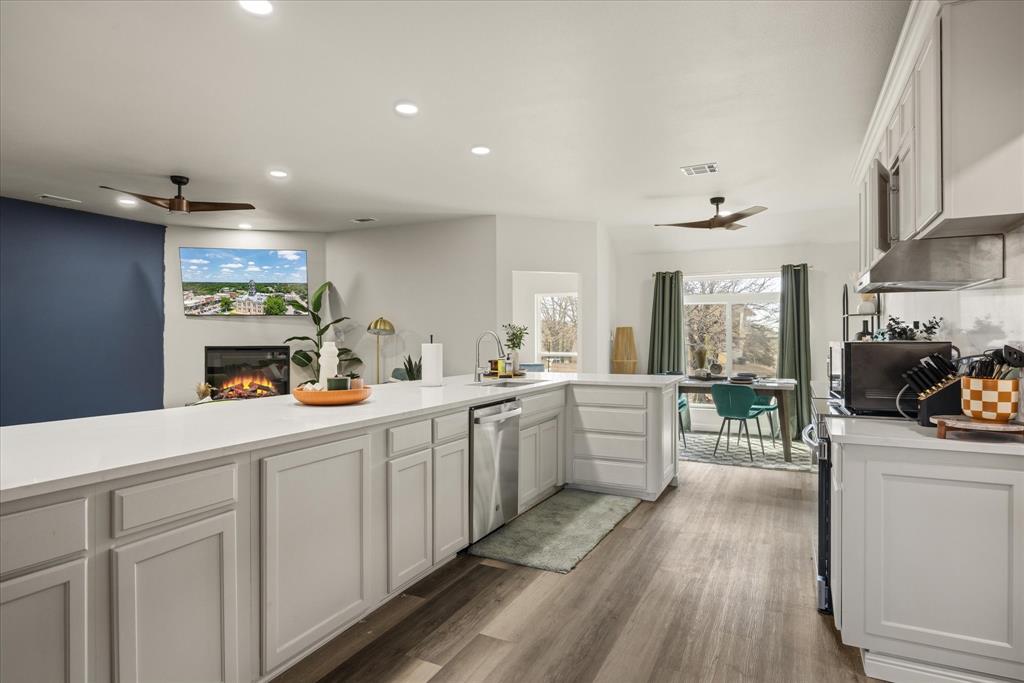 4801 West Wedgefield Road Granbury, TX 76049 - Photo 10 of 40 a large kitchen with a lot of counter space and a wooden floor