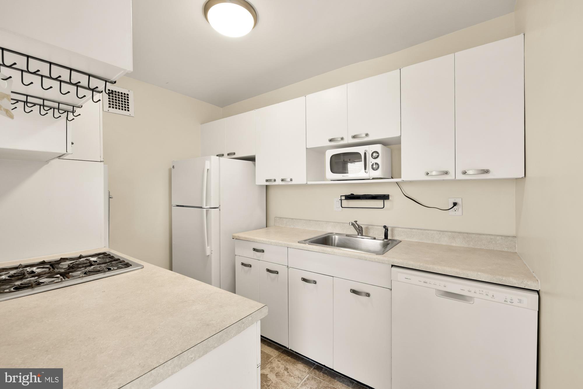 4390 Lorcom Lane, Unit 503 Arlington, VA 22207 - Photo 11 of 31 Modern kitchen with sleek white cabinetry.