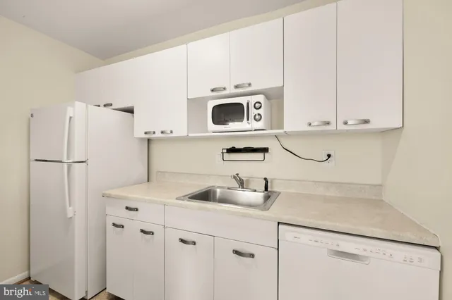 a kitchen with stainless steel appliances white cabinets and a refrigerator