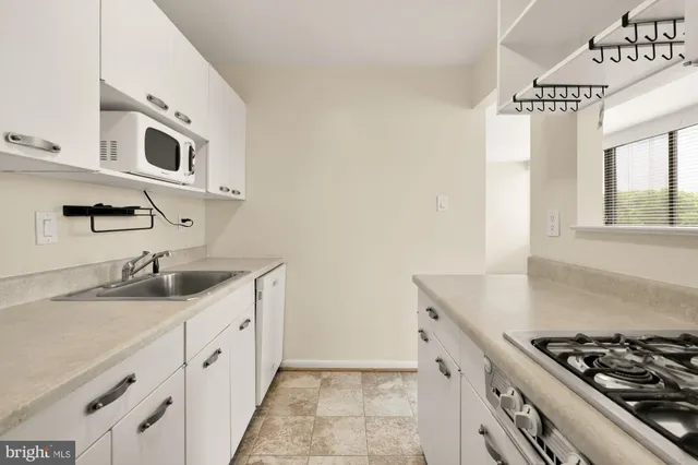 a kitchen with granite countertop a sink stove and cabinets