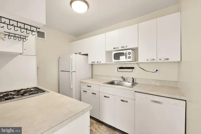 a kitchen with white cabinets and white appliances