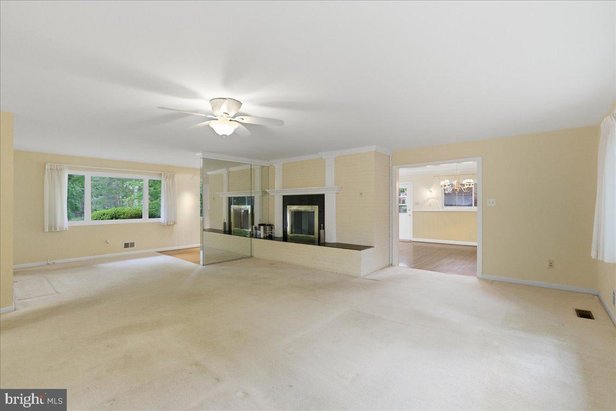 18309 Cabin Road Triangle, VA 22172 - Photo 9 of 42 an empty room with windows and chandelier fan